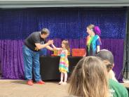 Magician, his helper and a little girl
