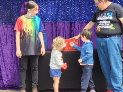 Two small children assist the team from Dealightful open a magic box